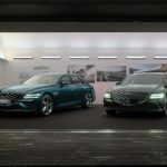 Two Genesis G80 models on display at a modern car exhibit, highlighting sleek design and luxury features.