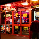 man in red shirt standing near store