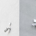 three white CCTV cameras mounted on wall